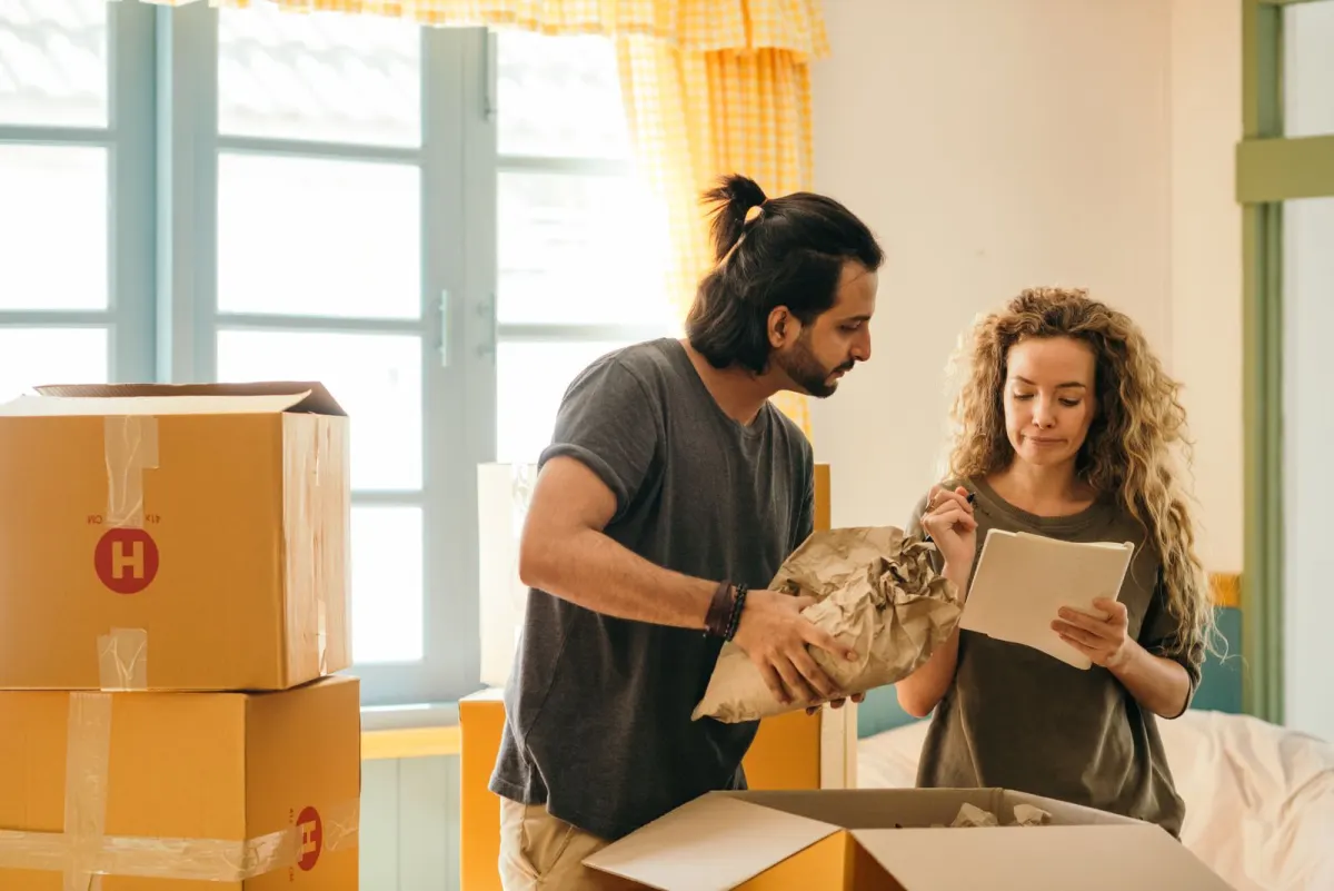 Couple working through a checklist while packing boxes before moving day